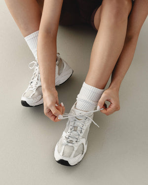 Active woman tying her gym shoes