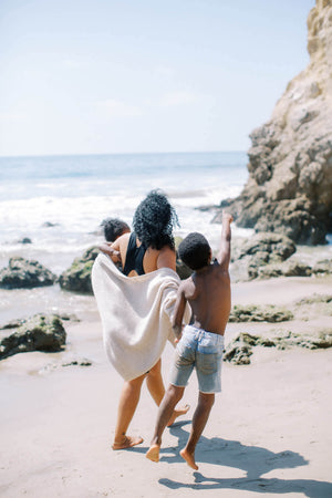 Mom walking on the beach with her kids—living freely with pelvic floor support that moves with real life.
